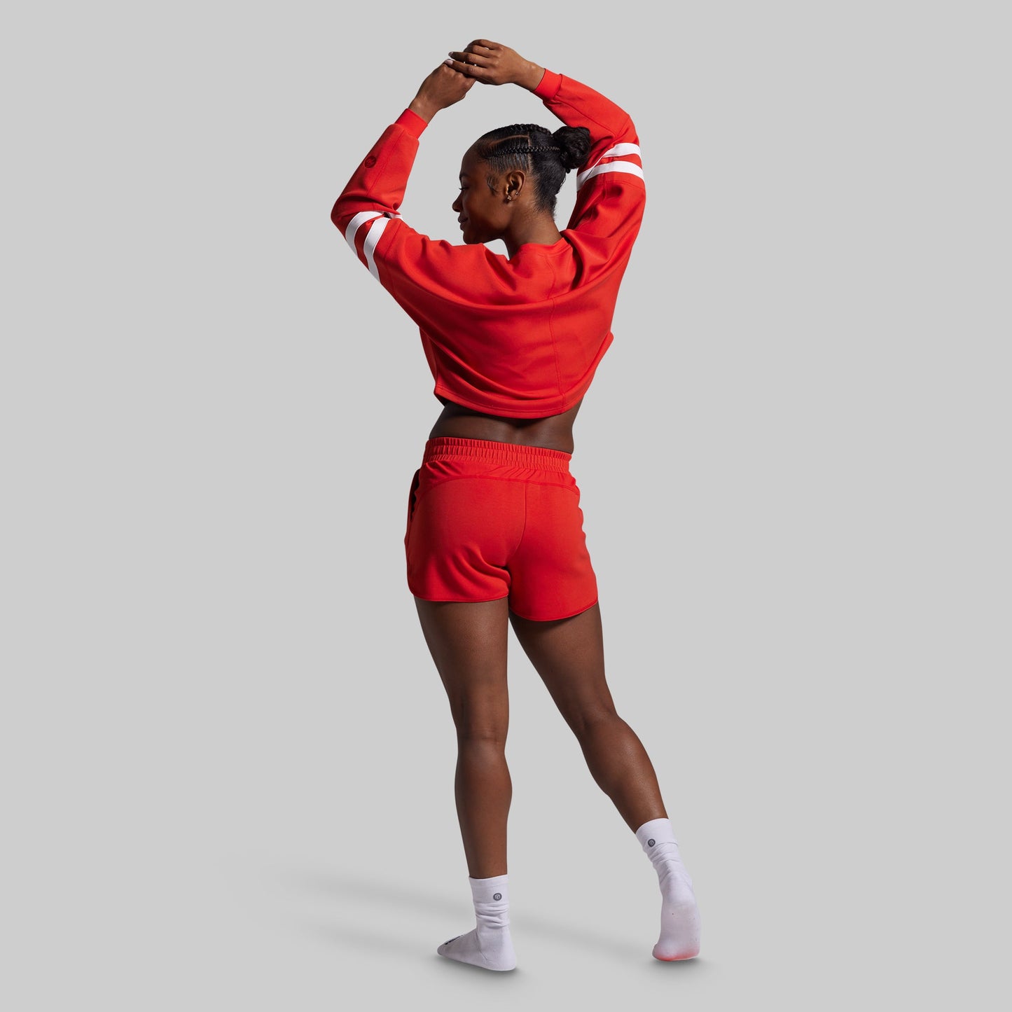 Person wearing a red tracksuit on a gray background