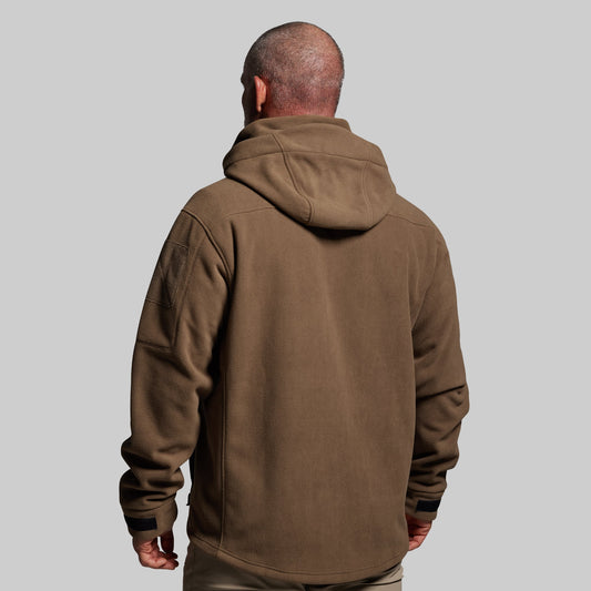 Man wearing a brown hoodie from behind on a gray background