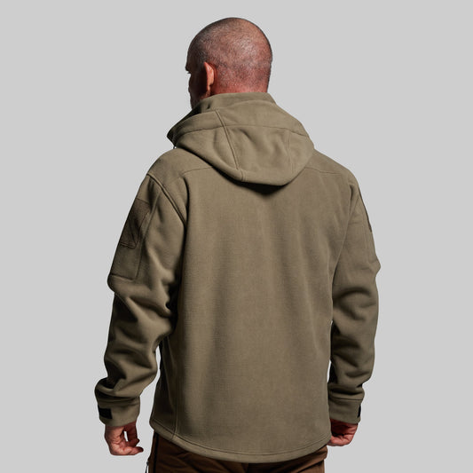 Person wearing a green jacket with a hood on a gray background