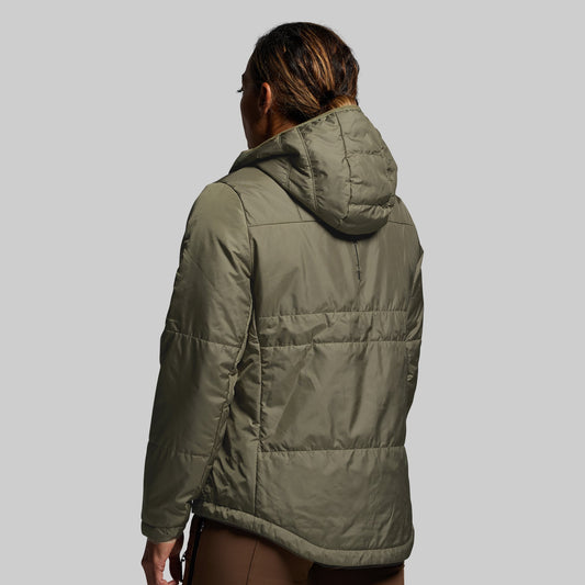 Person wearing a green puffer jacket on a plain background