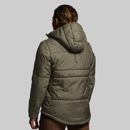 Person wearing a green puffer jacket on a gray background