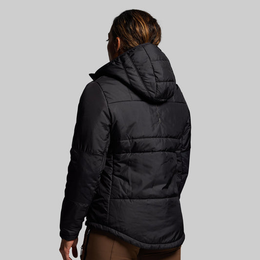 Person wearing a black puffer jacket on a gray background