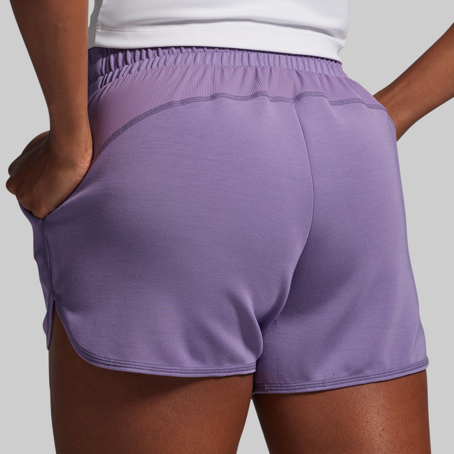 Purple athletic shorts worn by a person on a light gray background