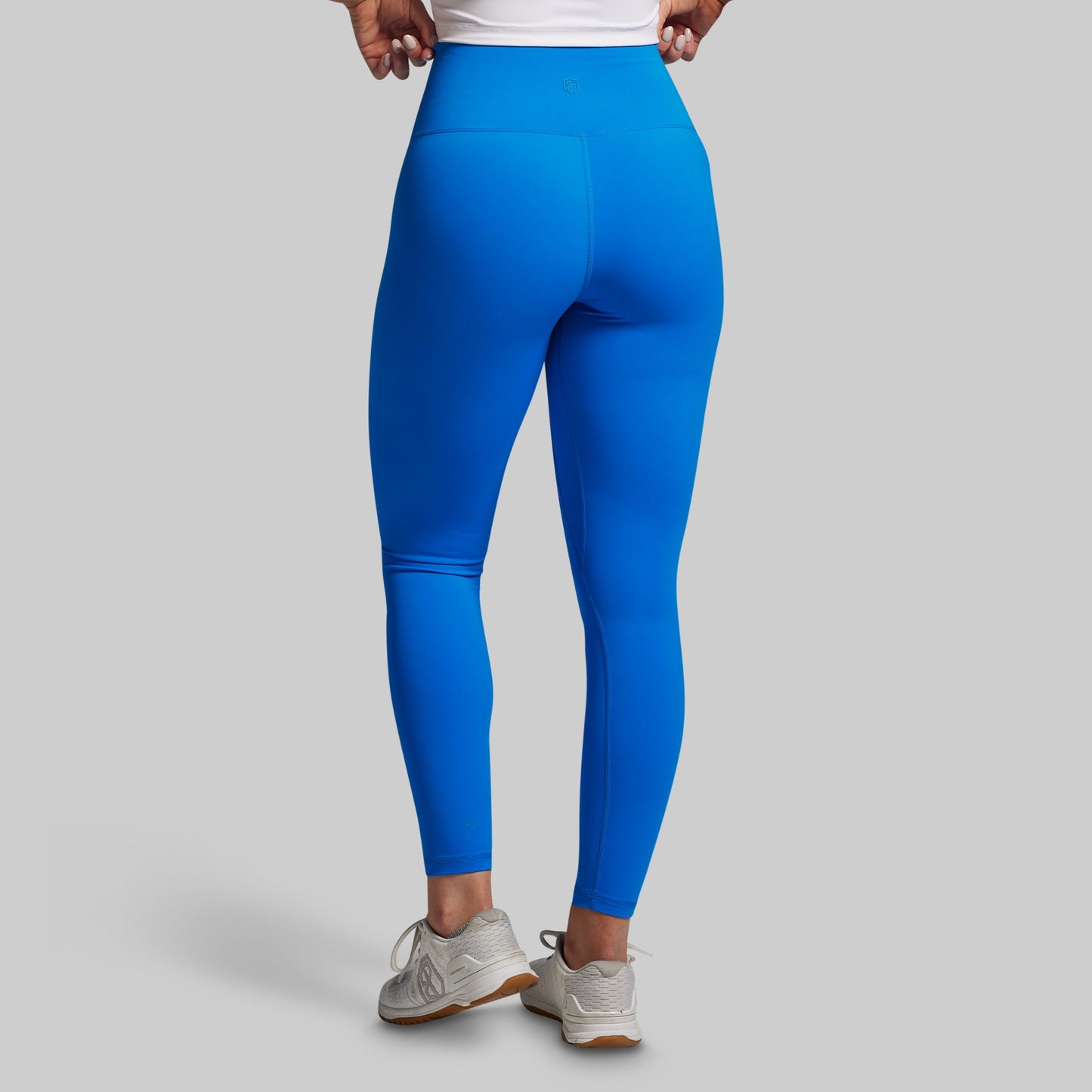 Blue leggings worn by a person on a gray background