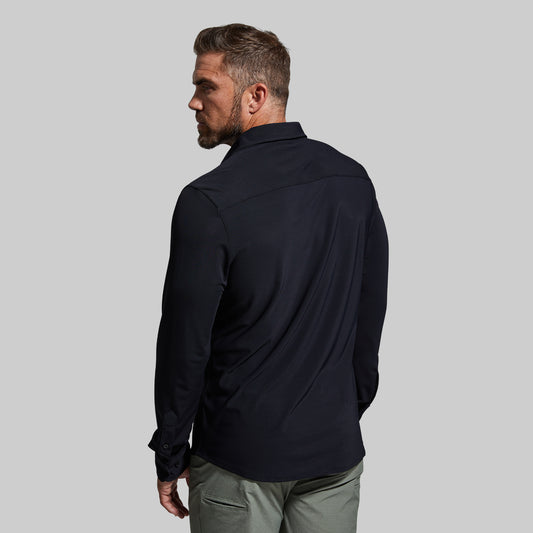 Man wearing a black shirt and green pants on a gray background