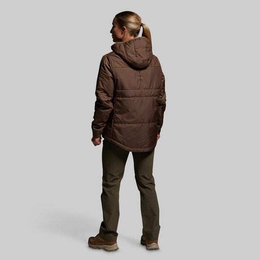 Person wearing a brown jacket and pants on a light gray background