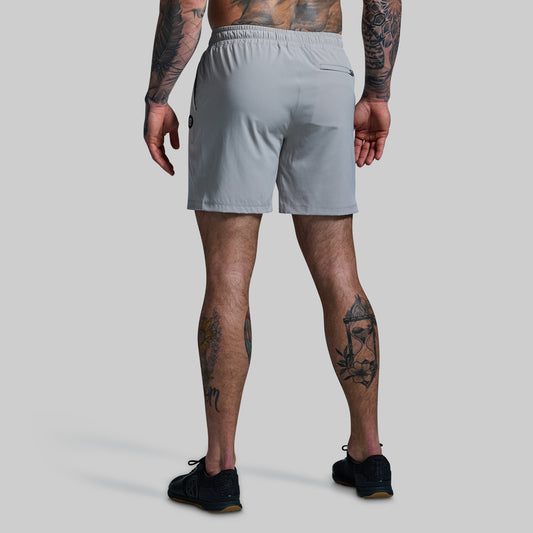 Person wearing light gray shorts on a plain background