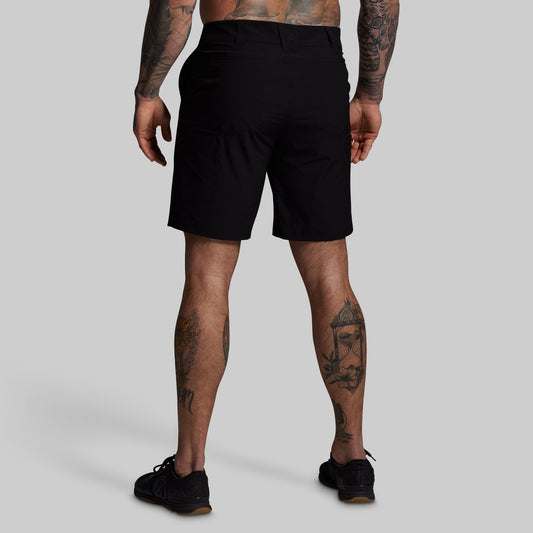 Person wearing black shorts on a gray background