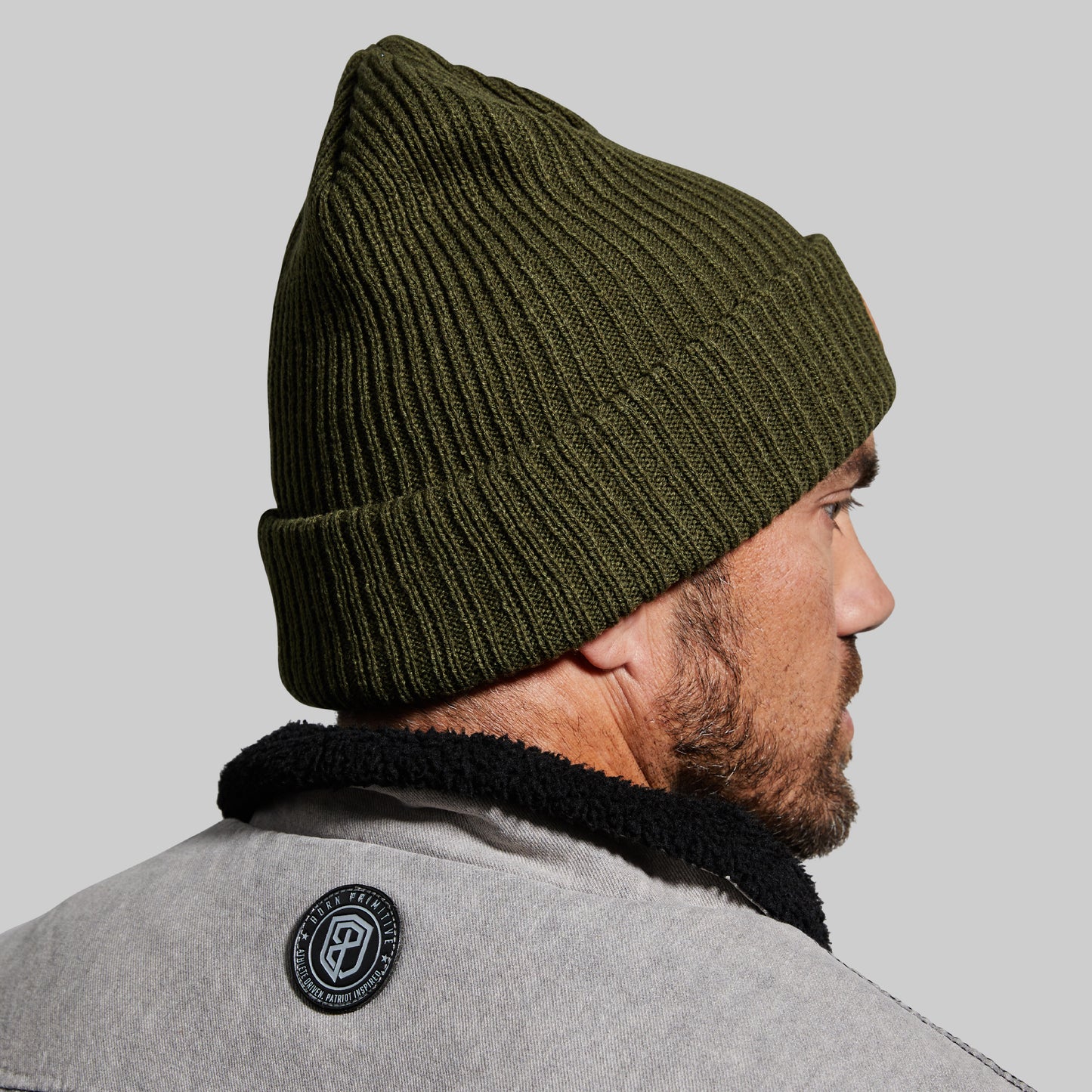 Man wearing a green beanie on a gray background