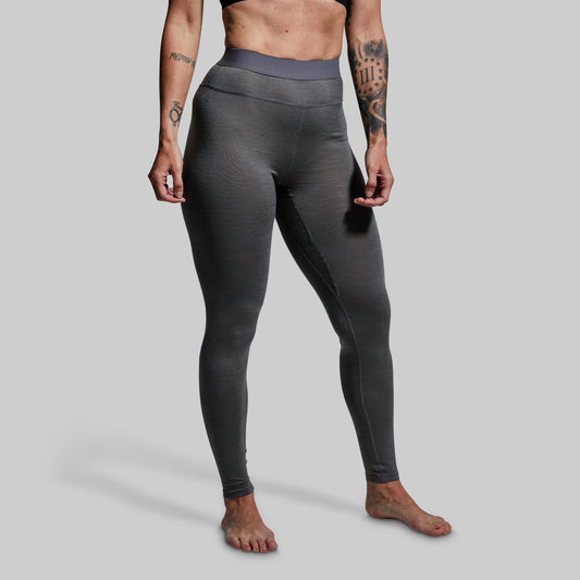 Person wearing gray base layer bottoms on a plain background
