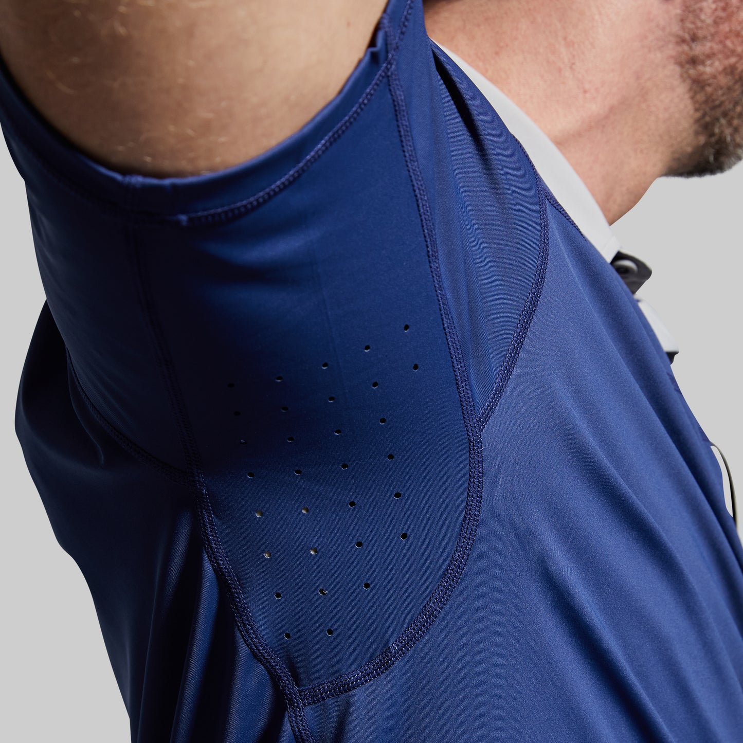 Close-up of a blue athletic shirt with perforated design on a gray background