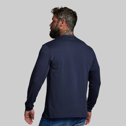 Man wearing a navy long-sleeve shirt on a gray background
