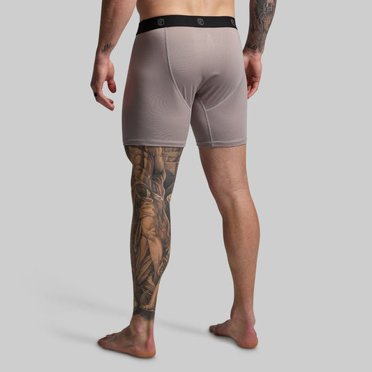 Man wearing gray boxer briefs on a plain background
