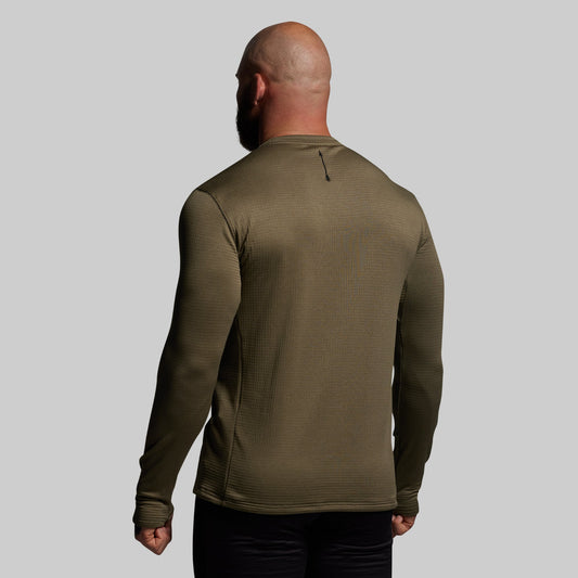 Man wearing a green long-sleeve shirt against a gray background