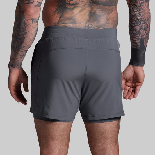 Person wearing gray athletic shorts on a plain background