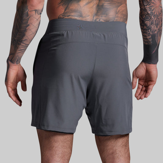 Person wearing gray shorts on a plain background
