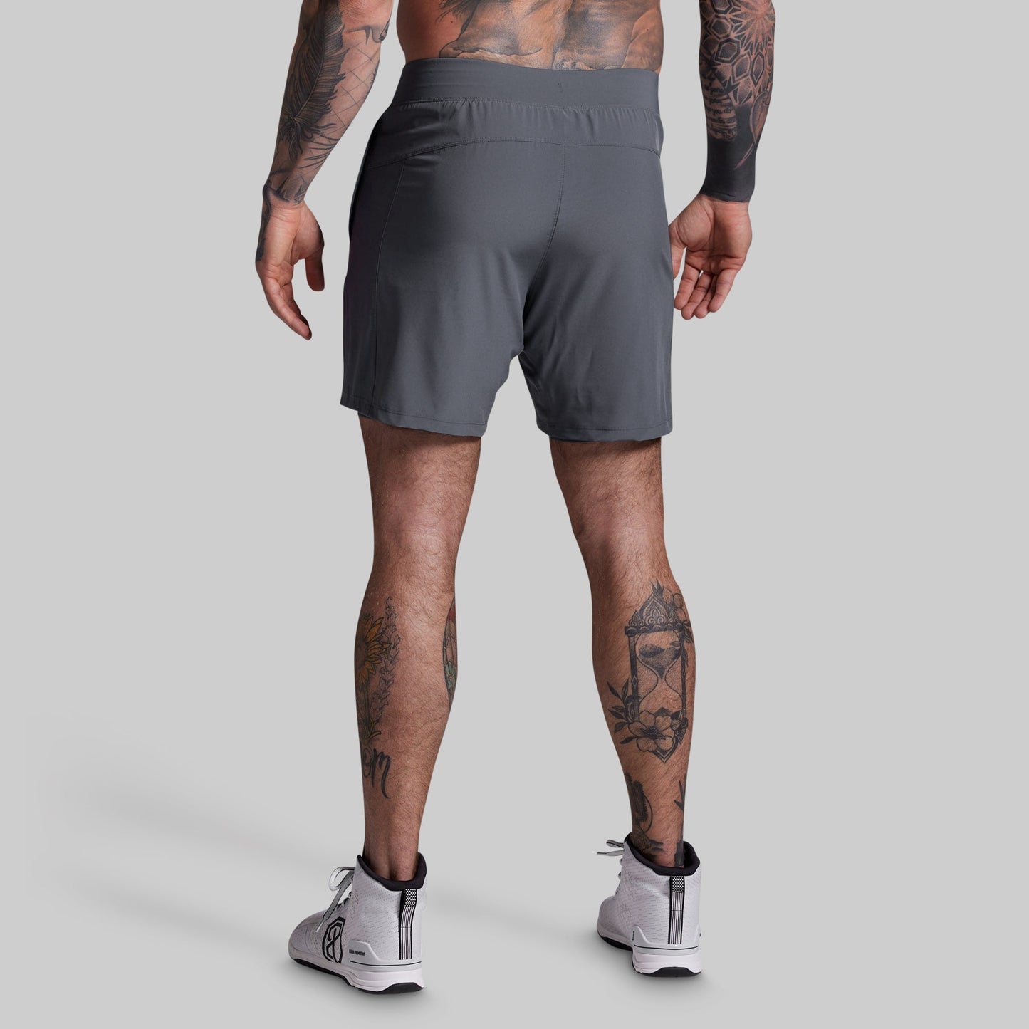 Person wearing gray athletic shorts on a plain background