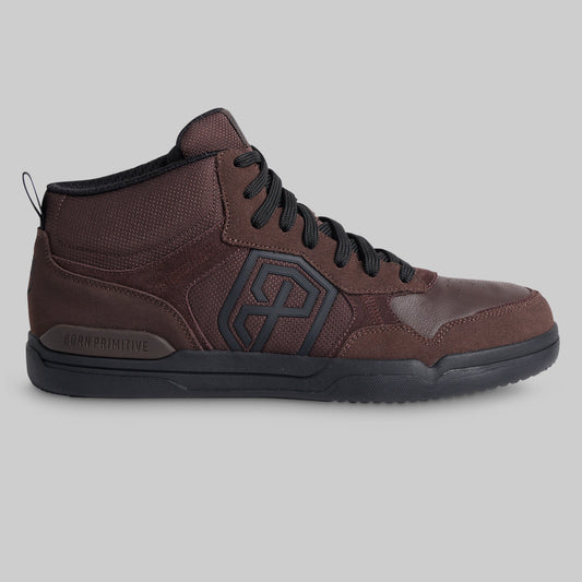 A dark brown mid-top sneaker with black laces, a black outsole, and a black geometric logo on the side, shown against a solid gray background.