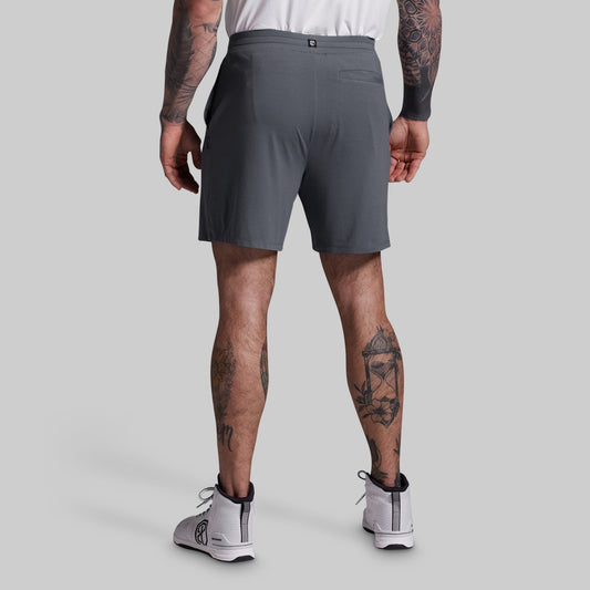 Person wearing gray athletic shorts on a plain background