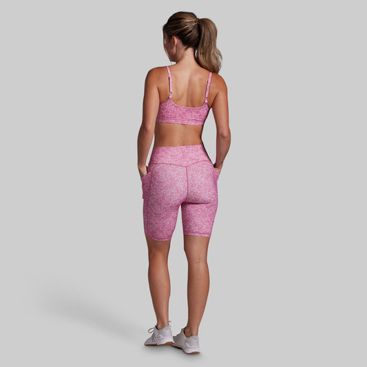 Woman wearing a pink athletic outfit on a gray background