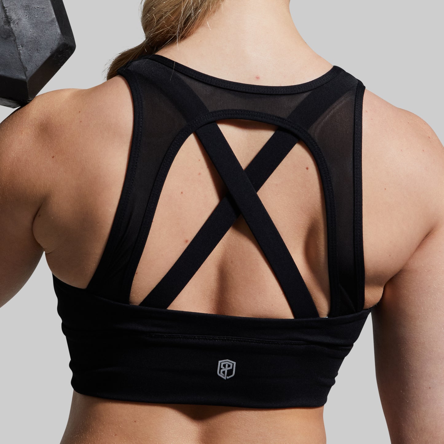 Black sports bra with criss-cross back design on a neutral background