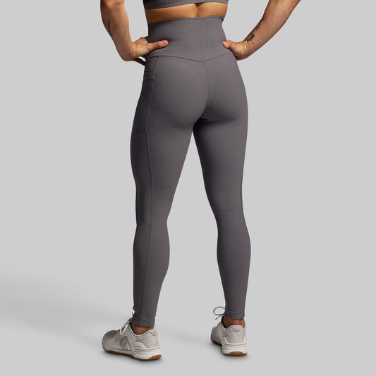 Person wearing gray leggings on a plain background