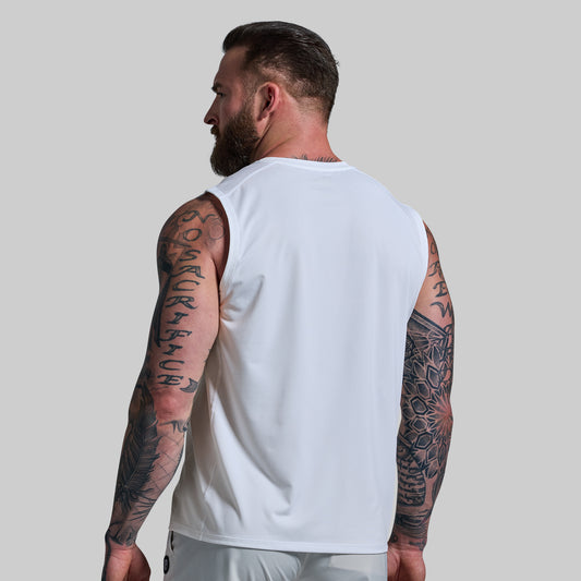 Man wearing a white sleeveless shirt with tattoos on arms against a plain background