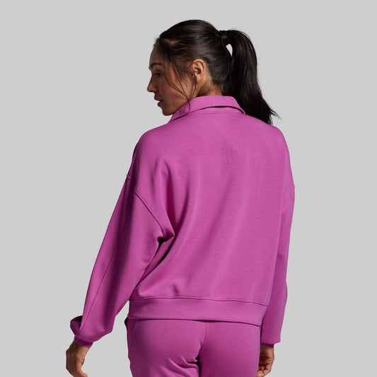 Person wearing a purple tracksuit on a gray background