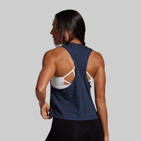 Person wearing a navy tank top with cut-out design on a gray background