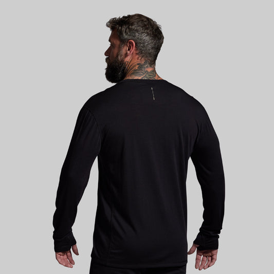Man wearing a black long-sleeve shirt on a gray background