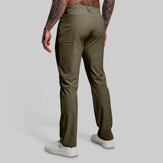 Person wearing olive green pants on a gray background