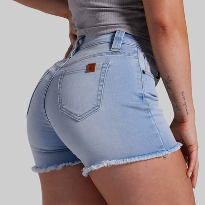 Light blue denim shorts worn by a person on a plain background