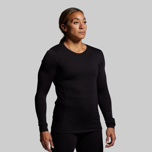 Person wearing a black long-sleeve shirt against a gray background