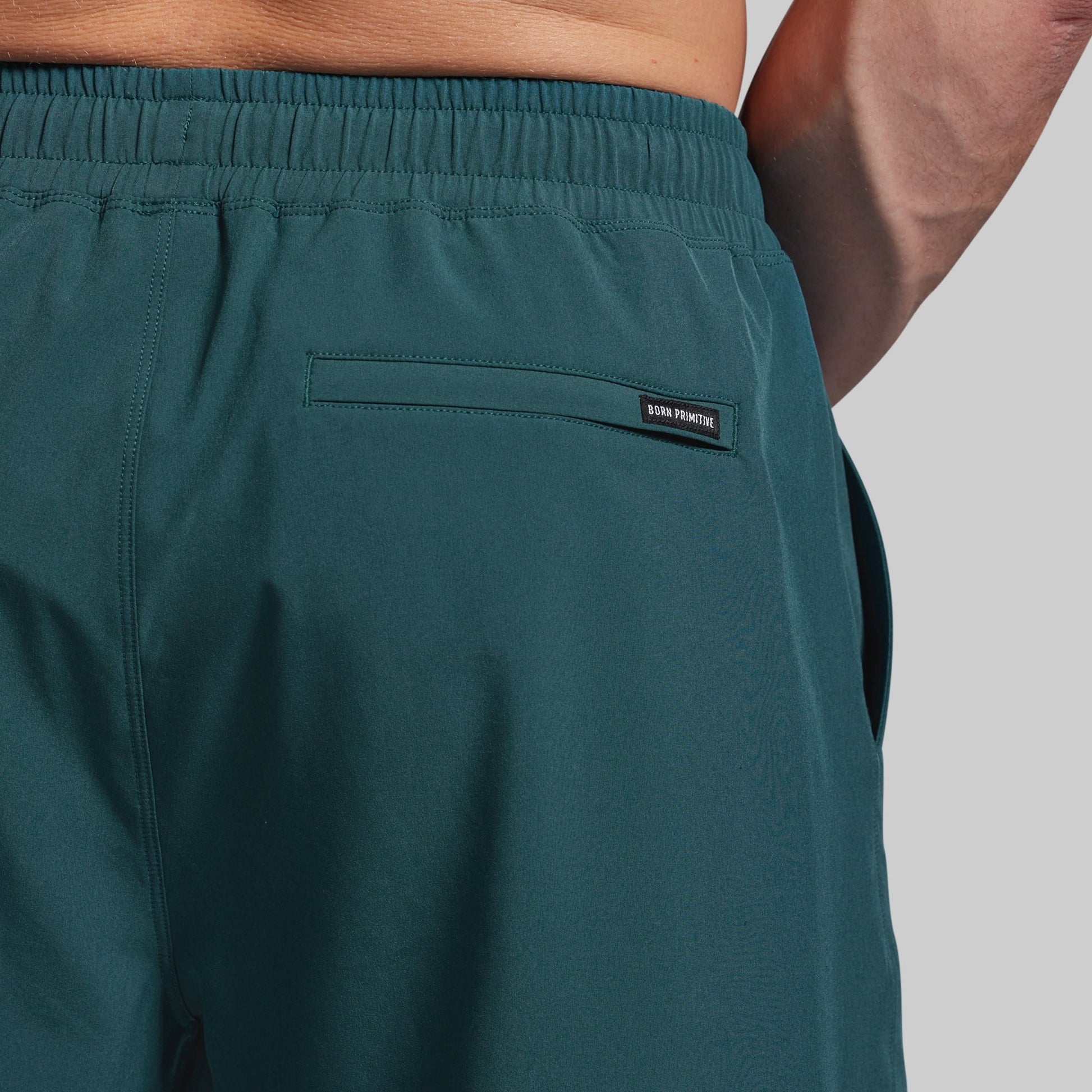 Teal shorts with a brand label on a gray background