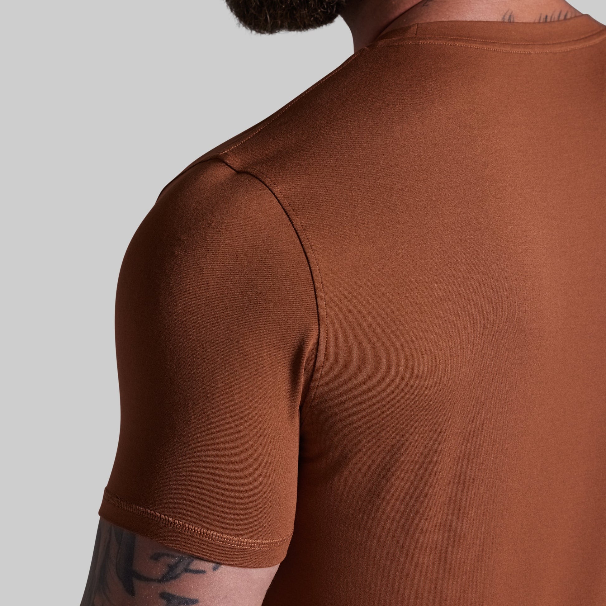 Brown t-shirt worn by a person on a light gray background