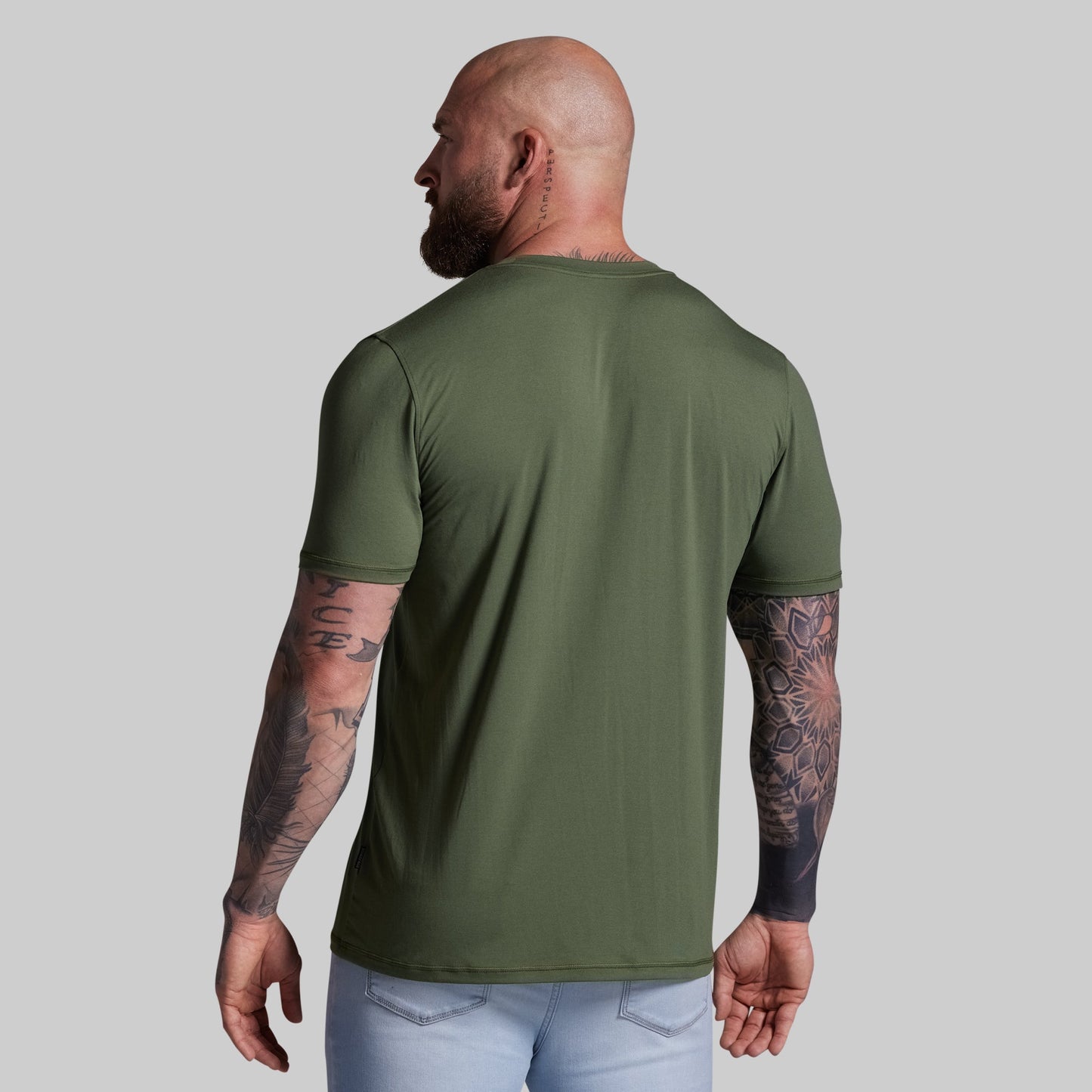 Man wearing a green t-shirt on a gray background