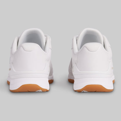 White sneakers with brown soles on a light gray background