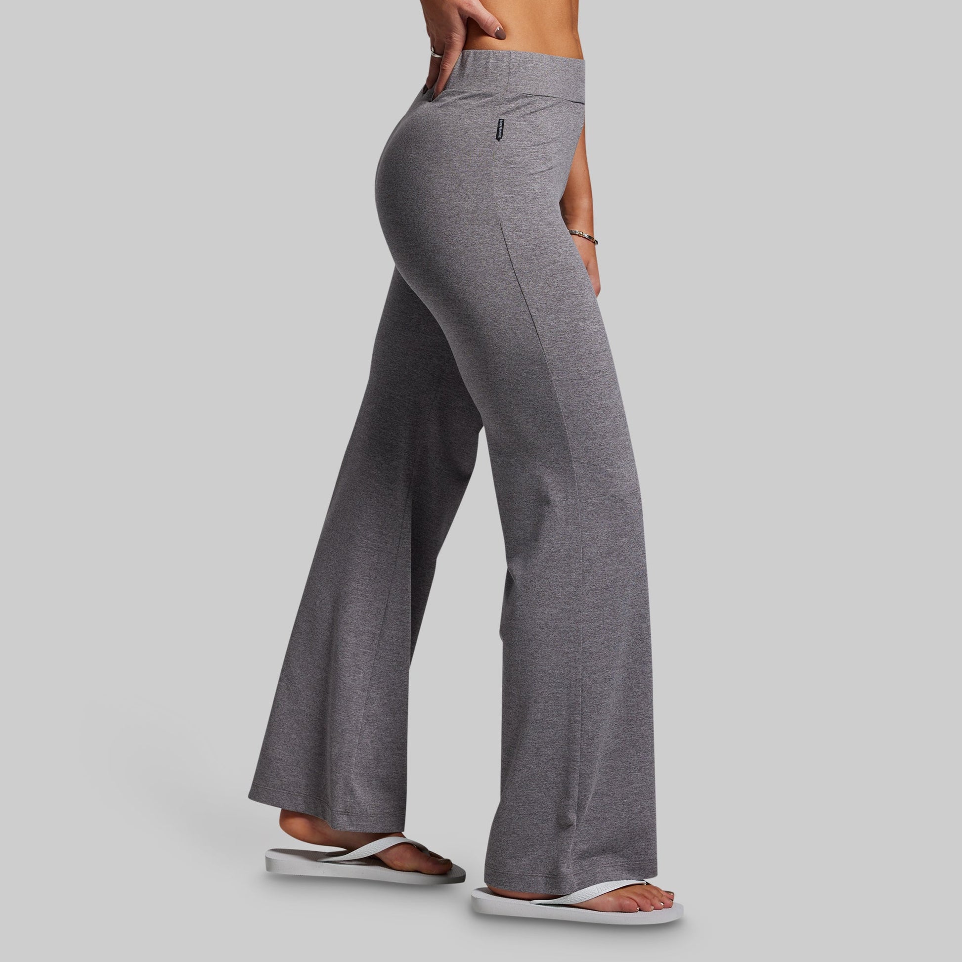 Gray flared pants worn by a person on a gray background