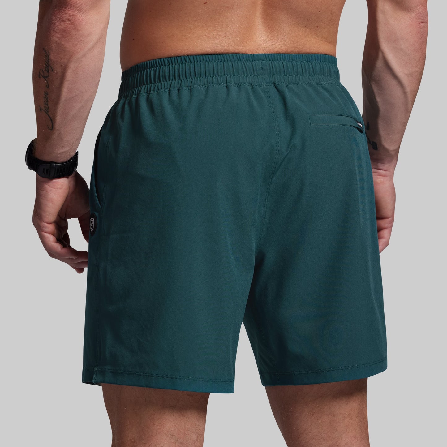 Teal shorts worn by a person on a plain background