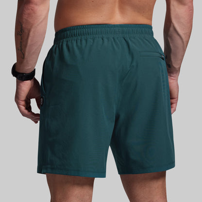 Teal shorts worn by a person on a plain background