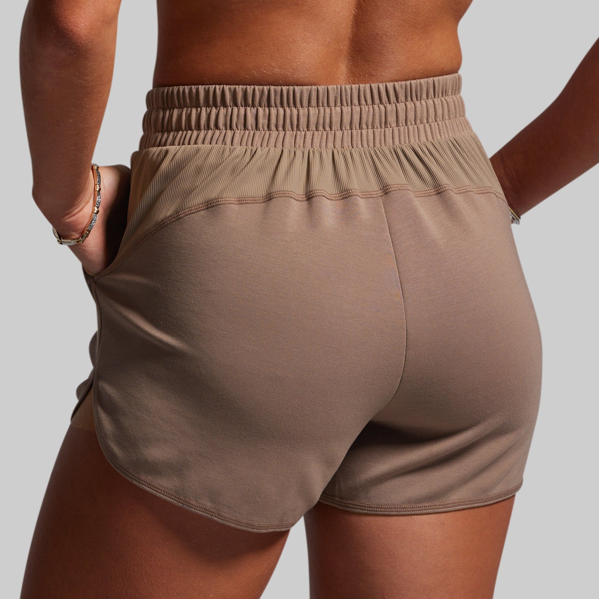 Brown shorts worn by a person on a plain background
