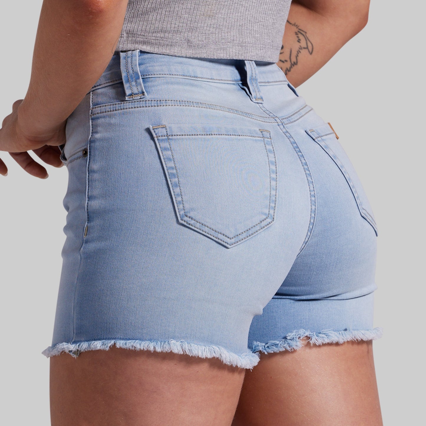 Light blue denim shorts worn by a person on a plain background
