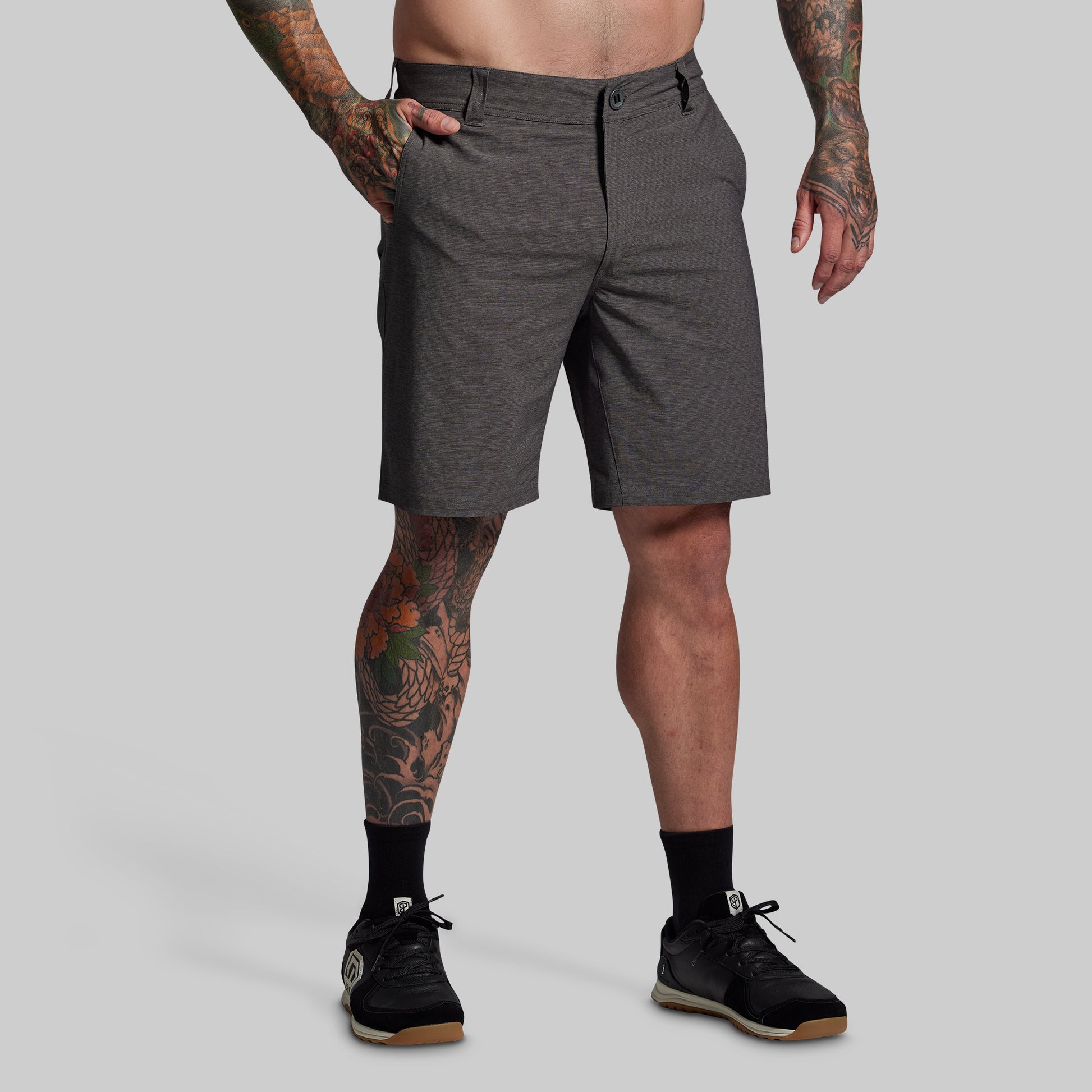 Person wearing gray shorts on a plain background