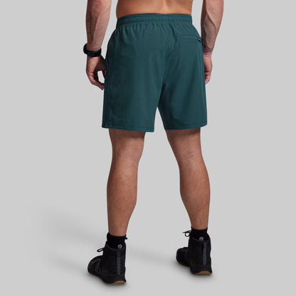 Person wearing teal shorts on a gray background