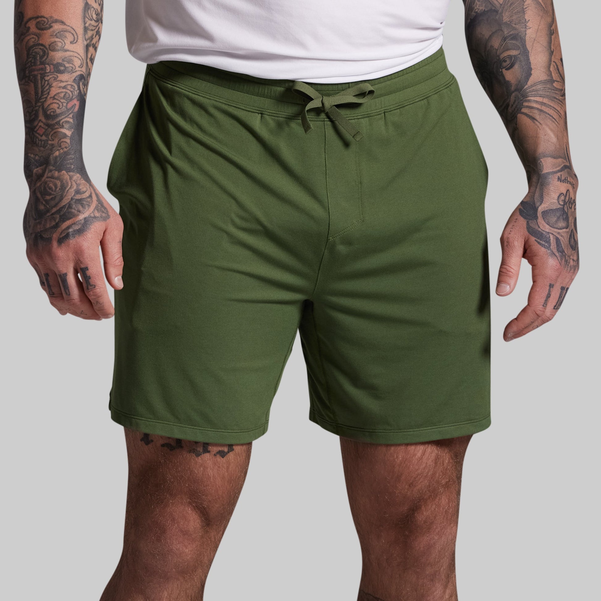 Person wearing green shorts on a plain background
