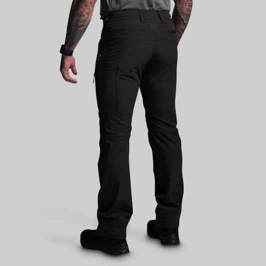 Person wearing black pants on a gray background