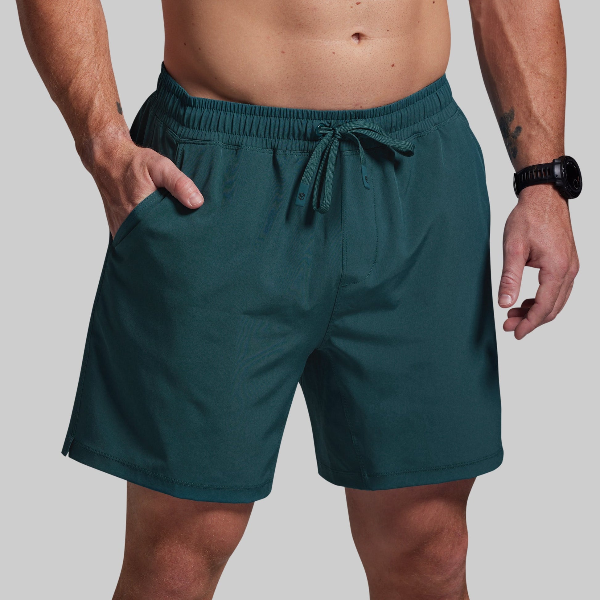 Teal shorts worn by a person on a plain background