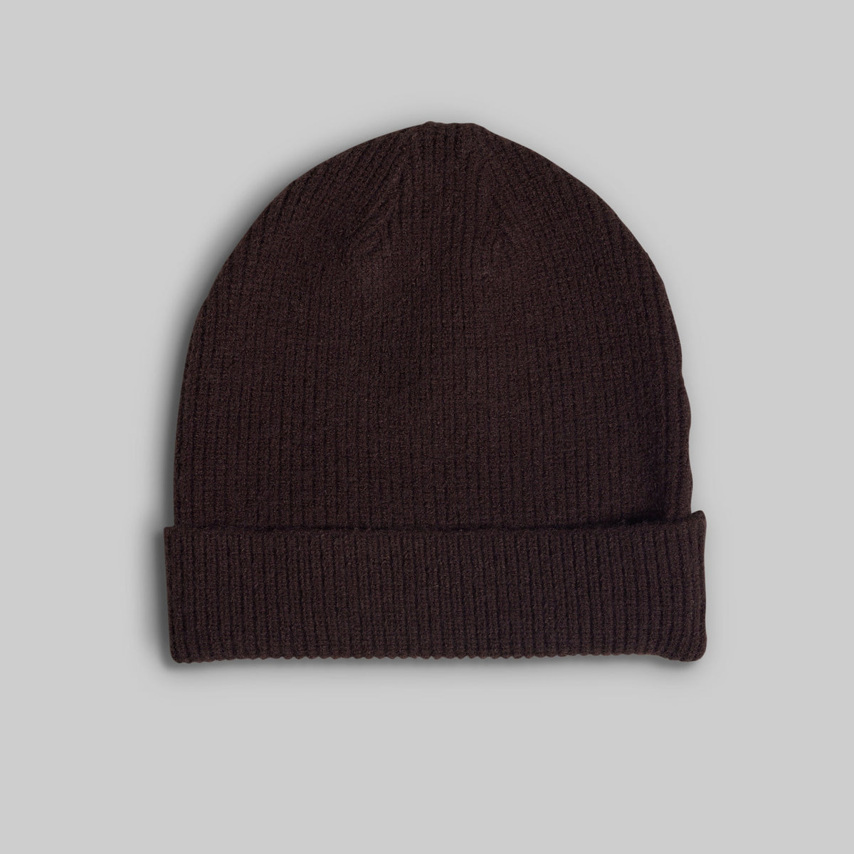 A dark brown ribbed knit beanie hat with a folded cuff, shown against a solid light gray background.