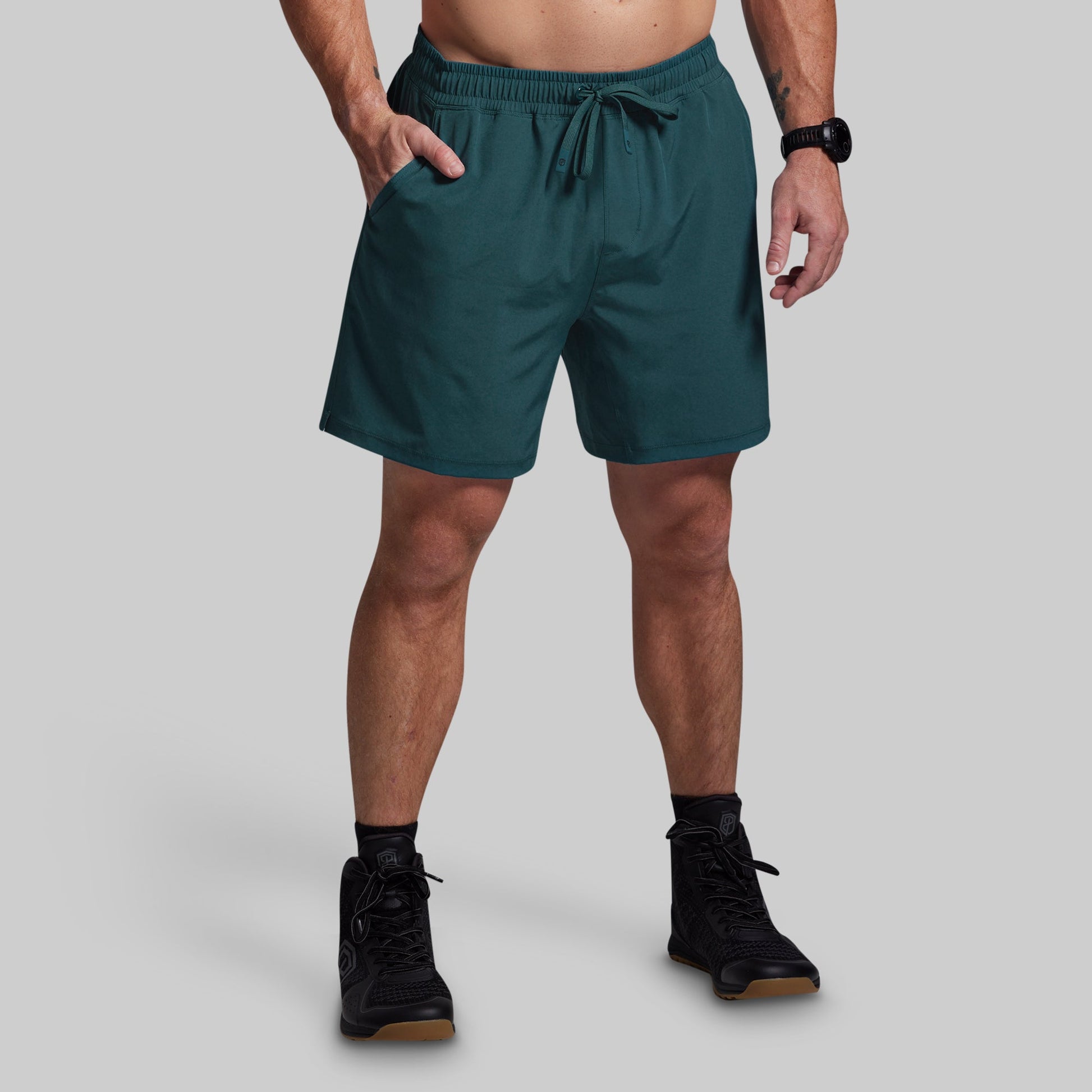 Person wearing teal shorts on a plain background