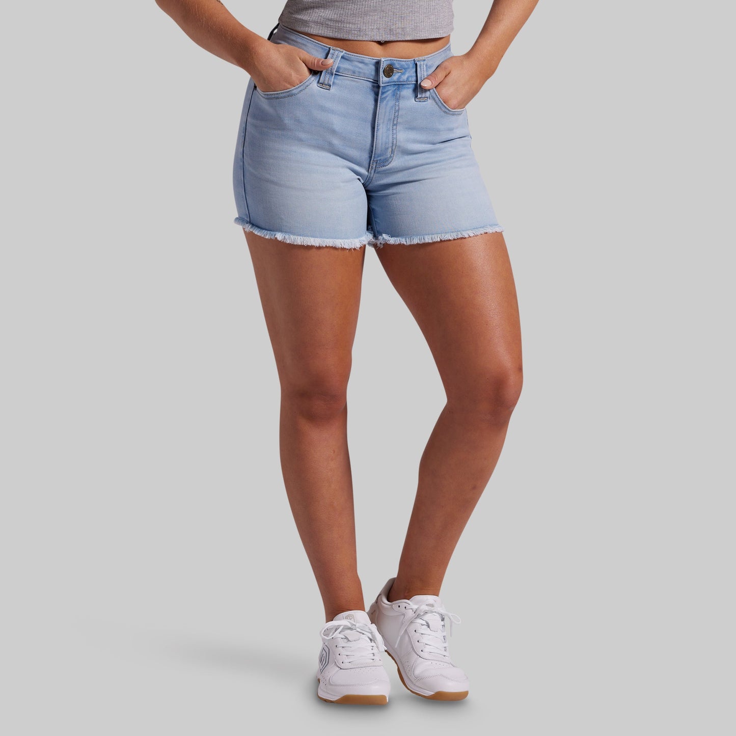 Person wearing light blue denim shorts on a gray background